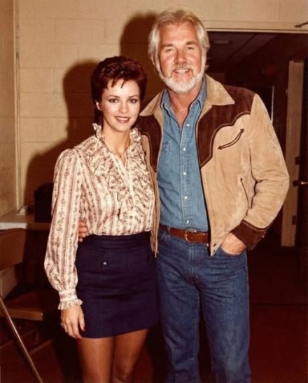 Leyenda de la música country posa con su esposa actriz: ¡pero los fans no dejan de mirar a la estrella pop de los años 80 que los acompaña!